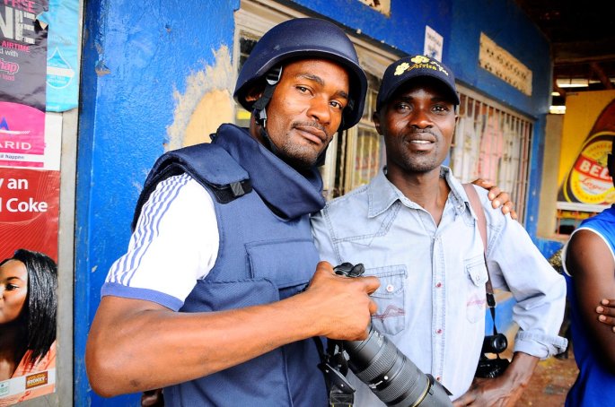Justin (with a cap) on assignment with a Photojournalist