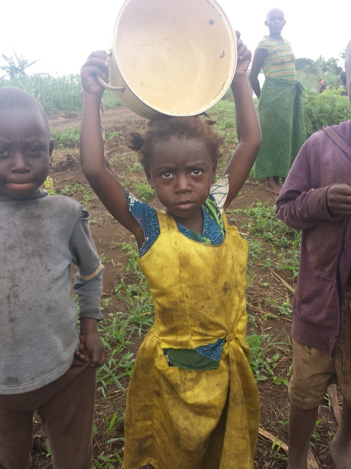 A young Congolese refugge girl carries an empty pan. Food for children is difficult to get for newly arrived refugees. Mostly they get maize flour and posho. Mostly children meals are given to very young ones.